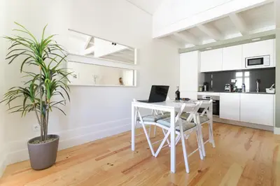 a white kitchen with a white table and a plant at Msc Flats in Porto