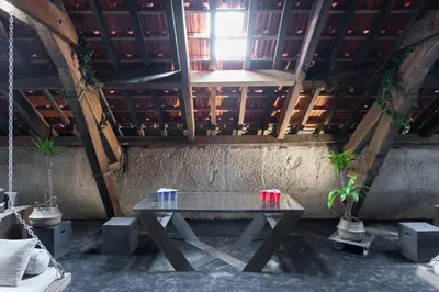 a picnic table in a room with a wooden ceiling at The Passenger Hostel in Porto