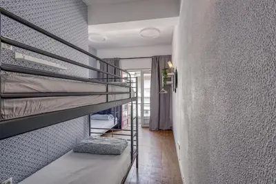 a room with two bunk beds on a wall at Travel & Live Hostel in Porto