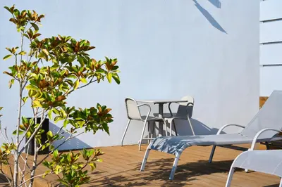 a patio with chairs and a table and a plant at Serviced Apartments Boavista Palace in Porto