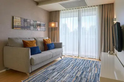 a living room with a couch and a television at Serviced Apartments Boavista Palace in Porto