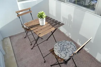a wooden bench with a potted plant and a chair at RockInn Porto in Vila Nova de Gaia