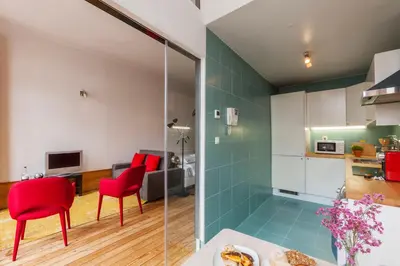 a kitchen and living room with red chairs and green tiles at Go2oporto - Fontainhas Apartments in Porto