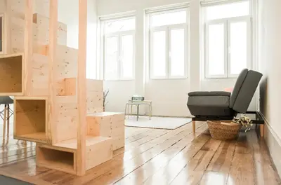 a living room with a chair and a book shelf at Zelije Apartments Trindade in Porto