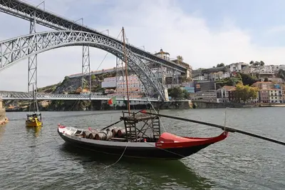 a boat in the water in front of a bridge at FLH Porto Stylish Apartment in Porto