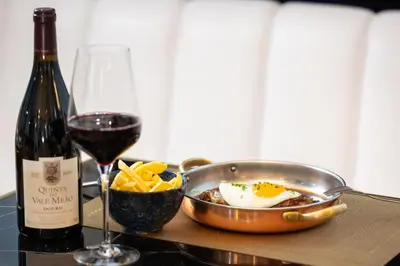 a bottle of wine and a bowl of food and a glass of wine at Hotel Cristal Porto in Porto