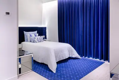 a bedroom with blue curtains and a bed with a blue rug at Hotel Cristal Porto in Porto