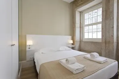 a bedroom with a bed with two towels on it at RVA - Clerigos Apartments in Porto
