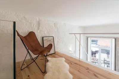 a living room with a chair and a window at LovelyStay - Cativo Mezzanine Studio in Porto