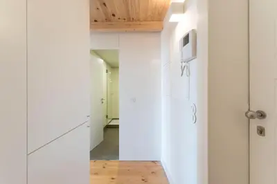 a kitchen with white cabinets and a hallway at LovelyStay - Cativo Mezzanine Studio in Porto