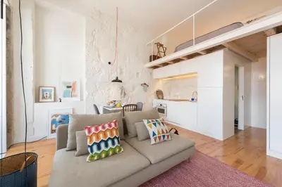 a living room with a couch and a kitchen at LovelyStay - Cativo Mezzanine Studio in Porto