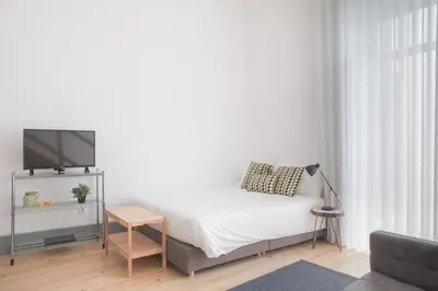 a bedroom with a bed with a tv and a table at Citybreak-apartments Coliseu in Porto