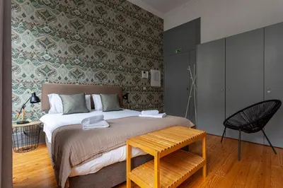 a bedroom with a bed with a table and a chair at Citybreak-apartments Coliseu in Porto