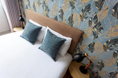 a bedroom with a bed with blue and gold wallpaper at Citybreak-apartments Coliseu in Porto