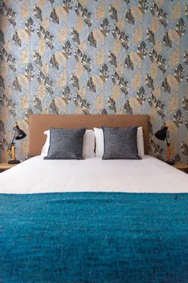a bedroom with a bed with blue and orange wallpaper at Citybreak-apartments Coliseu in Porto