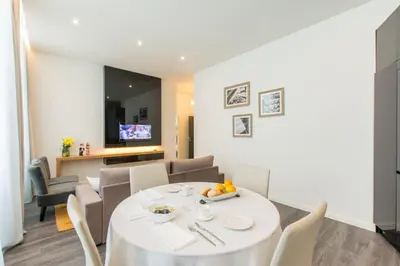 a dining room and living room with a white table and chairs at LETHESHOME Apartments in Porto