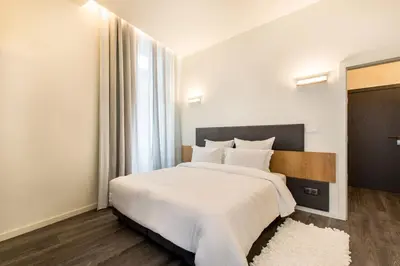 a bedroom with a large white bed with a large window at LETHESHOME Apartments in Porto