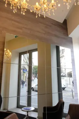 a mirror in the lobby of a building with a chandelier at LETHESHOME Apartments in Porto