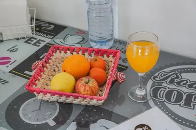 a basket of fruit on a table with a glass of orange juice at Apartamento À Francos Balcony in Porto