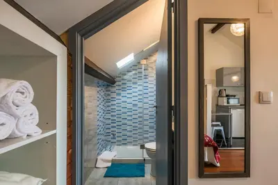 a glass door leading into a bathroom with a mirror at Apartamento À Francos Attic in Porto