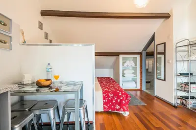 a kitchen and dining room with a table and stools at Apartamento À Francos Attic in Porto