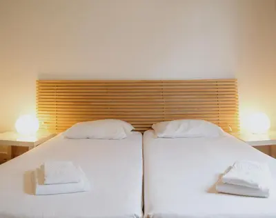 two beds in a bedroom with two towels on them at Porto Spot Hostel in Porto