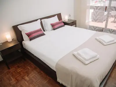 a bedroom with a large white bed with two pillows at OPORTO GUEST Cedofeita Terrace in Porto