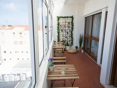 a balcony with wooden benches and a window at OPORTO GUEST Cedofeita Terrace in Porto