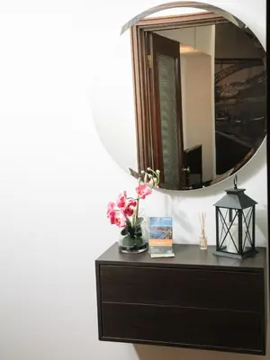a mirror on top of a dresser with flowers on it at OPORTO GUEST Cedofeita Terrace in Porto