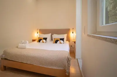 a bedroom with a bed with two pillows and a window at Bonfim 234 Townhouse in Porto