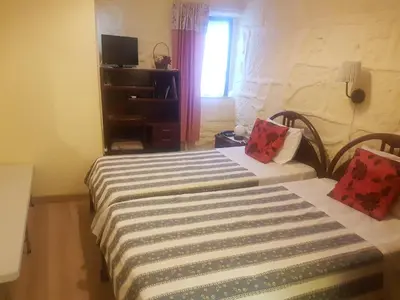 a bedroom with two beds and a window at Caldeira Guest House in Porto