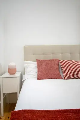 a bedroom with a white bed with a red blanket at CL Fernandes Tomás I in Porto