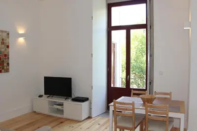 a living room with a dining room table and a television at CL Fernandes Tomás I in Porto