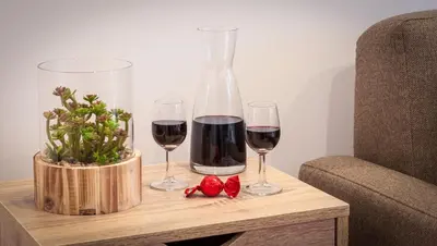 a table with two glasses of wine and a vase at São Bento Golden Flat in Porto