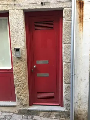 a red door on the side of a building at São Bento Golden Flat in Porto