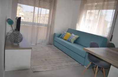 a living room with a blue couch and a table at Modern and Cozy Apartment in Vila Nova de Gaia
