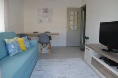 a living room with a blue couch and a television at Modern and Cozy Apartment in Vila Nova de Gaia
