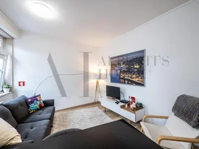 a living room with a couch and a tv at Alberti's House Oporto Central Apartment in Porto
