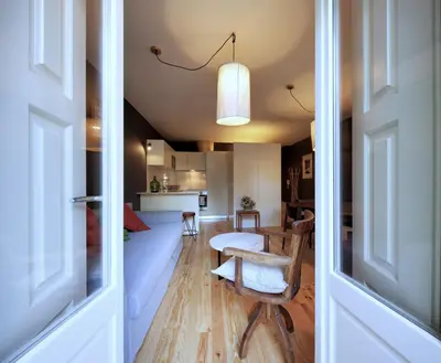 a living room with a table and a kitchen at Oporto Maison Batalha in Porto