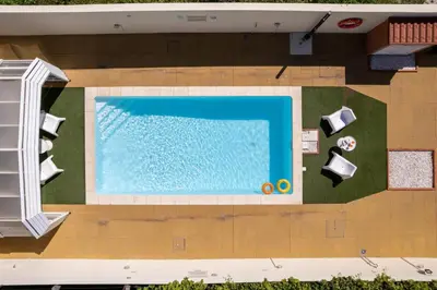 a table and chairs sitting next to a swimming pool at 733 Costa Cabral Metro Residence in Porto