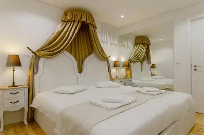 a bedroom with a large white bed with curtains at Oporto Vintage Apartment in Porto