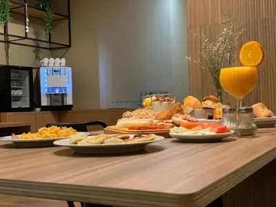 a table topped with plates of food and orange juice at Spot Apartments Trindade in Porto