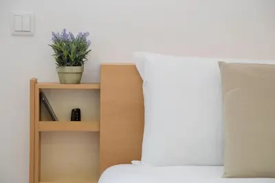 a bed with a wooden shelf with a plant on it at Spot Apartments Trindade in Porto