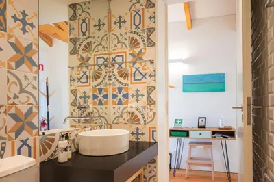 a bathroom with a sink and a tile wall at Panoramic luxury apartment w AC Downtown and Metro in Porto