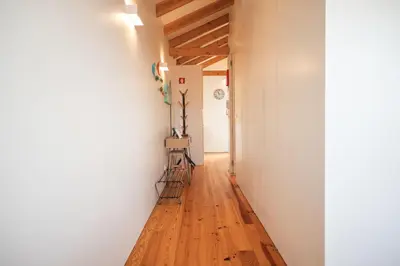 a hallway with white walls and a wooden floor at Panoramic luxury apartment w AC Downtown and Metro in Porto