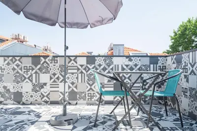 a patio with two chairs and an umbrella at Panoramic luxury apartment w AC Downtown and Metro in Porto