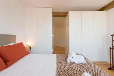 a bedroom with a bed with a pair of shoes on it at LovelyStay - Top Floor Balcony Apartment in Porto