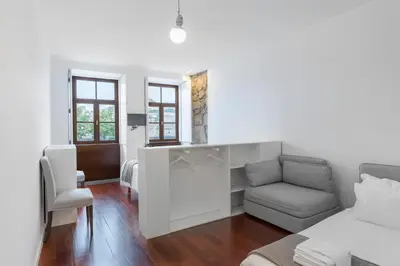 a white living room with a couch and a chair at Goabio apartments 2 river view in Porto