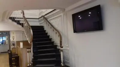 a staircase with a flat screen tv on the wall at Hotel Paulista in Porto