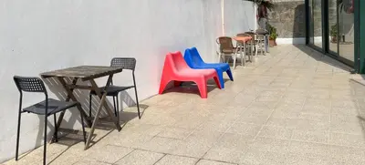 a row of colorful chairs and tables on a sidewalk at Hotel Porto Rico in Porto